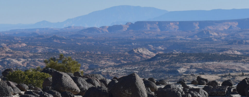 boulder mountain in the distance with black rocks in the foreground