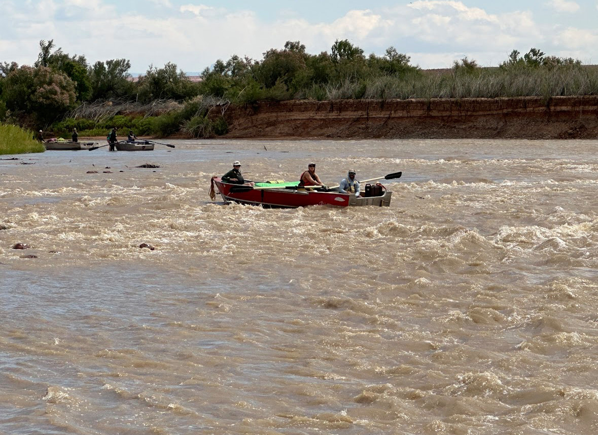 Boaters in boats on choppy water.
