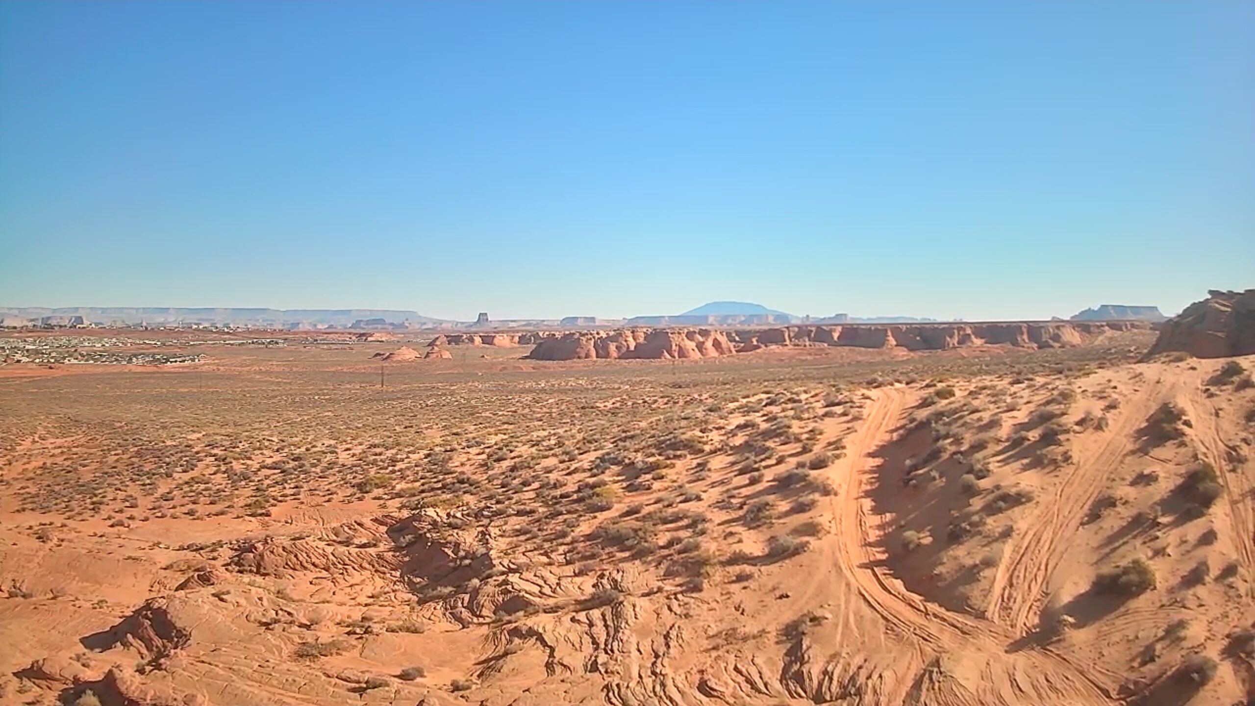 Aerial image of a red rock desert with dirt roads running through it.